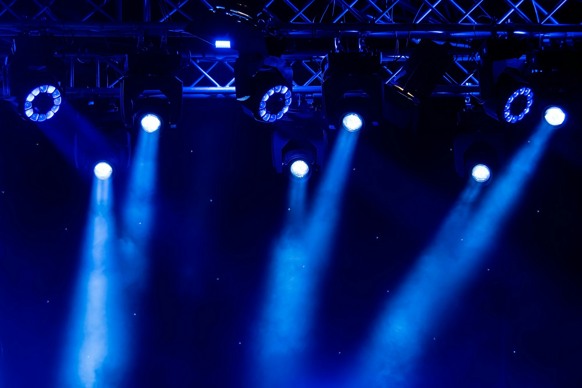 blue luminous rays from concert lighting against a dark background, musical instrument